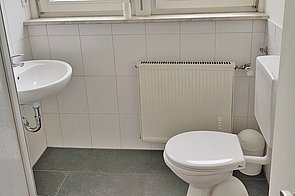 Bad mit Dusche, WC, Waschbecken und Fenster.